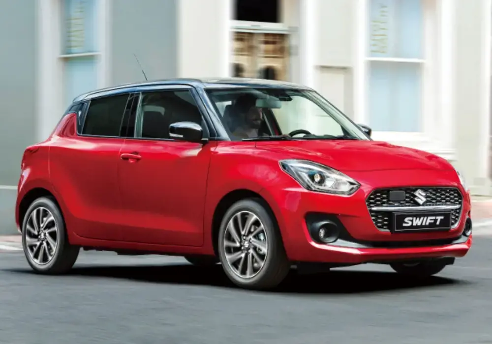 Suzuki Swift Híbrido rojo de nueva generación circulando por una calle urbana.